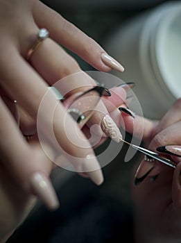 Woman in a nail salon receiving a manicure by a beautician with nail file woman