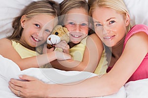 Woman napping in bed with her cute children