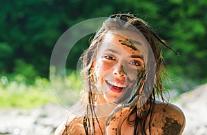Woman with natural mud mask. Beauty treatment and skincare. Happy girl applying black dirty face mask. Mud healthy scrub
