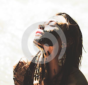 Woman with natural mud mask. Woman relaxing with a charcoal facial mask. Portrait of a beauty girl with spa mud mask on