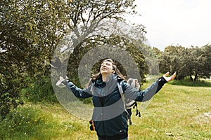 Woman in nature with open arms feeling the nature. Concept of lifestyle in freedom, adventure and active outdoor vacations