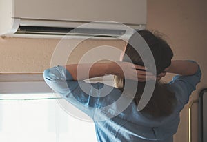 Woman near air conditioner.