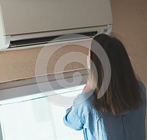 Woman near air conditioner.