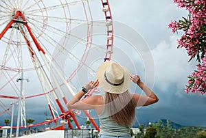 Woman near beautiful large Ferris wheel outdoors, back view. Space for text