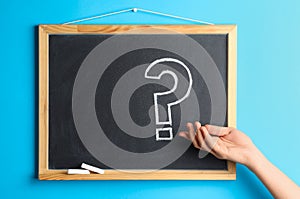 Woman near blackboard with question mark