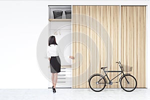 Woman near a built in wadrobe in a room with bike