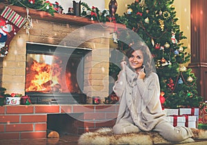 Woman near fireplace in Christmas decorated house