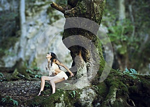 Woman near giant tree trunk in woods