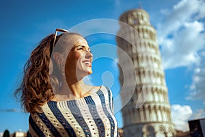 Woman near leaning tower in Pisa, Italy looking into distance