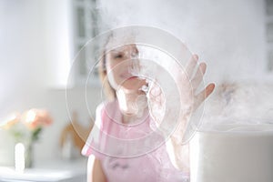 Woman near modern air humidifier in kitchen