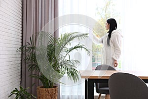 Woman near window in room with plants. Home design ideas