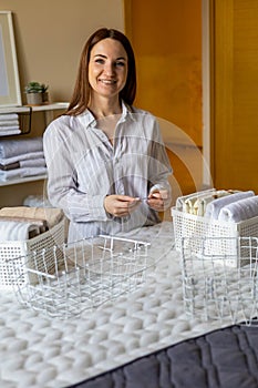 Woman neatly folded linens and towels use Marie Kondo method with sticky label tags