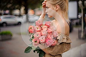 Woman neatly holds in her hand bouquet of stylish bright peony roses