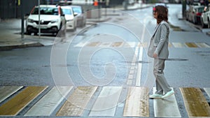 Woman with neck brace is walking on pedestrian crossing in city, curing of diseases of musculoskeletal system