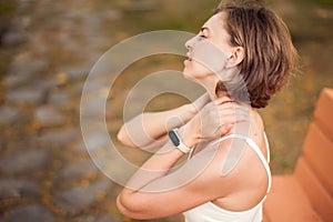 Woman with neck pain outdoor. Healthcare and medicine concept