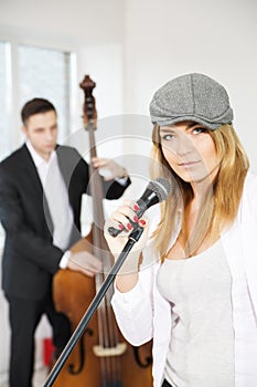 Woman next to microphone and contrabas