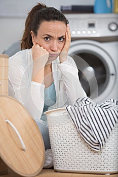 Woman next to pile dirty laundry