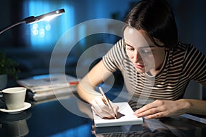 Woman in the night taking notes at home