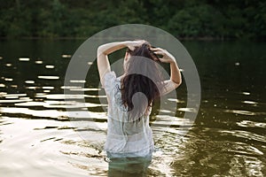 Woman in nightie is bathing in the river