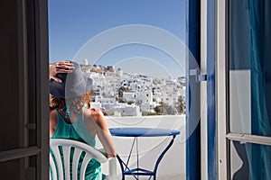 woman enjoying mykonos town view from terrace, Greece - summer holiday