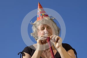 Woman with noisemaker on the party photo