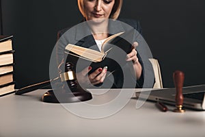 Woman with notary books in office. Wooden gavel with libra and laptop concept.