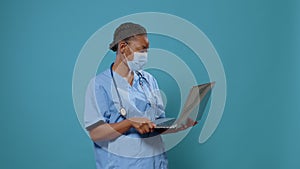 Woman nurse wearing face mask and using laptop