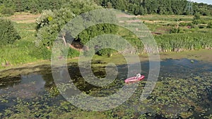 Woman with oar in hands is paddling in kayak on river. Female tourist is travelling along river in canoe. Girl traveller is explor