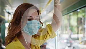 Woman observes safety precautions in public place and wears medical mask and gloves to protect against virus and