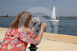 Woman observing through coin operated binocular