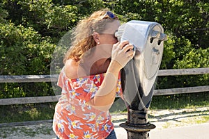 Woman observing through coin operated binocular