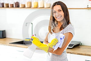 Woman with obsessive compulsive disorder cleaning kitchen with detergents, but everything is clean anyway.