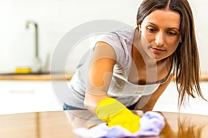 Woman with obsessive compulsive disorder cleaning kitchen with detergents, but everything is clean anyway.