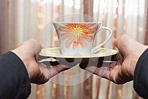 Woman offering a cup of tea blurring