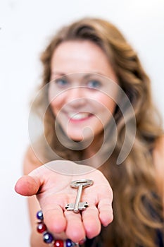 Woman Offering a Key, selective focus on the key and hand