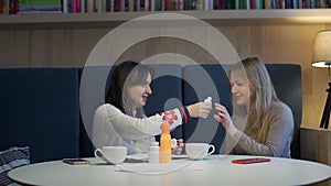 Woman Offers MLM Products to a Client in Cafe