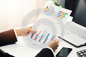 Woman at office analyzing business financial graph reports photo