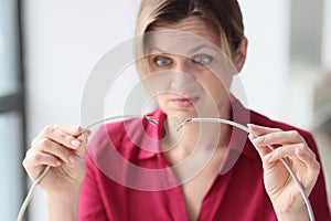 Woman in office with broken network cable in her hands