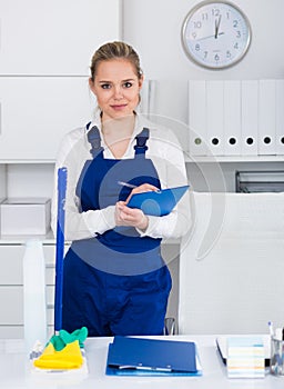 Woman office cleaner writing tasks