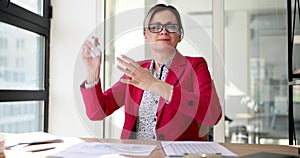 A woman in the office crumbles and throws paper