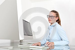 Woman in office at desk in front of computer, mouse click