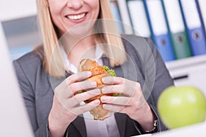 Woman at the office having lunch. Concept for healty or unhealthy food at work