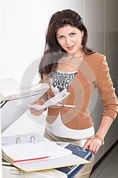 Woman in office near the copier with documents