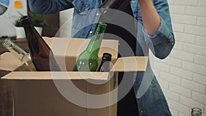 Woman in office putting glass waste in recycling bin