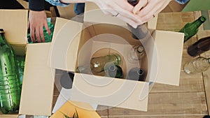 Woman in office putting glass waste in recycling bin