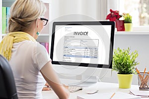 Woman in office with sample invoice document on computer photo