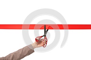 Woman in office suit cutting red ribbon on white, closeup