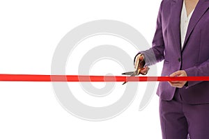 Woman in office suit cutting red ribbon on white, closeup