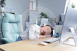 Woman office worker tired Asian sleeps on the desk, overtired sleeps in the day photo