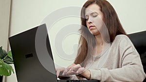 A woman in the office works on a modern computer. Business woman typing text on laptop keyboard. Female hands of a